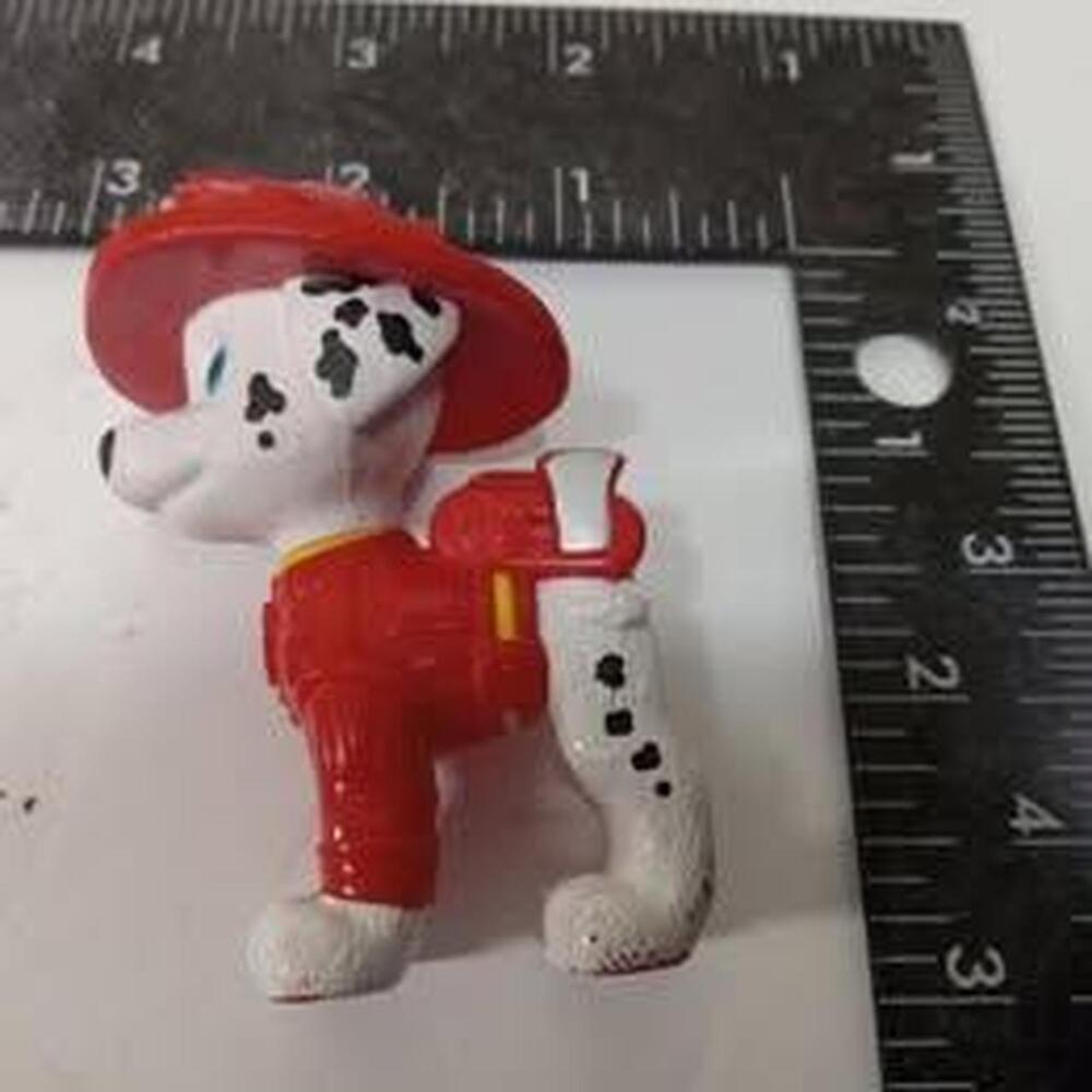 White and black dalmatian dog figure wearing a red firefighter helmet and suit.